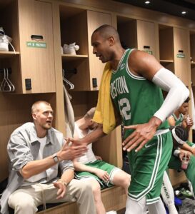 image of krisraps porzingis shake hands with Al horford during his first appearance in media after his injury.